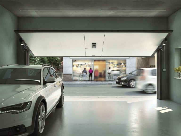 Une porte de garage sectionnelle ouverte dans un espace vide et moderne.