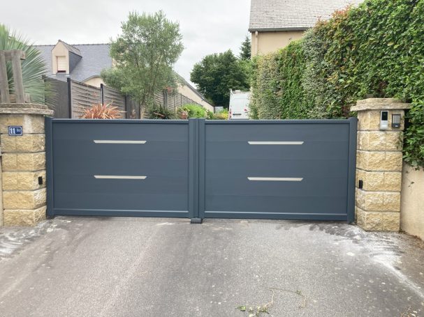 Portail en métal gris de style moderne, avec des bandes horizontales, sur route résidentielle.