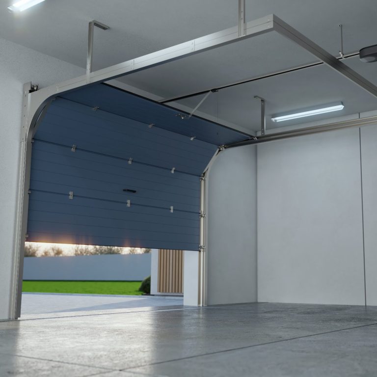 Intérieur d'un garage moderne avec porte sectionnelle ouverte et éclairage.